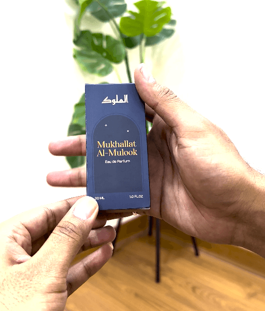 Hand holding Al-Mulook perfume box showing logo and premium packaging finish.