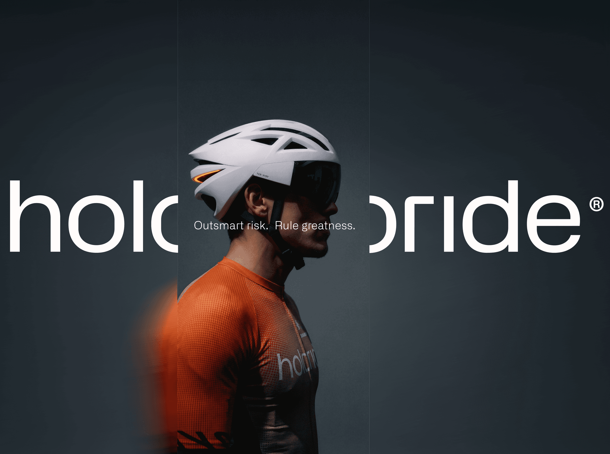 Holoride cyclist wearing a holoride helmet and branded jersey on a dark grey studio backdrop.
