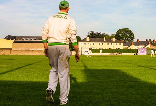 Cricket player standing on a pitch during s sunny evening