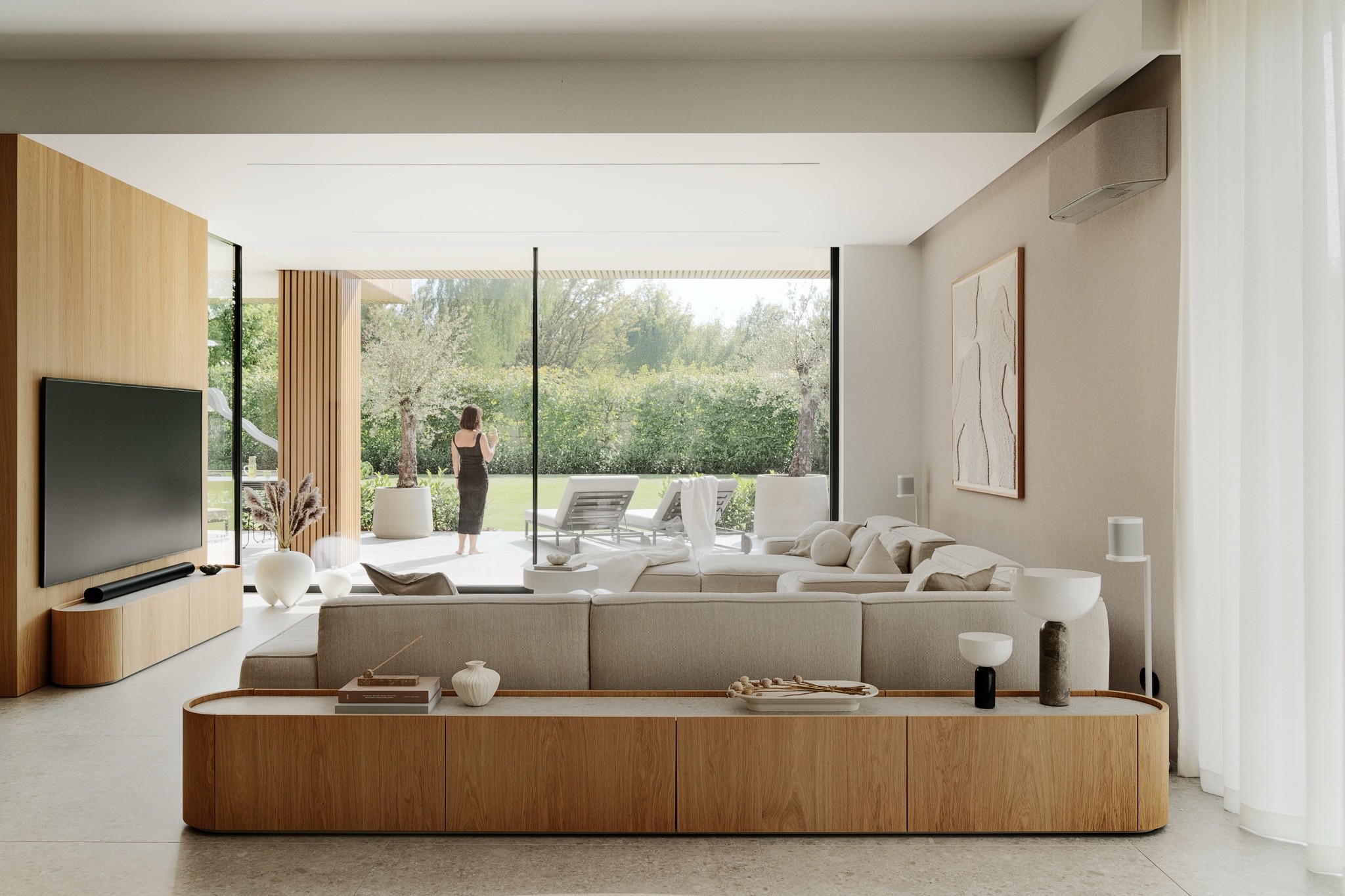 Salon z kremowymi obłymi sofami przy łukowej ścianie z drewnianych lameli - Dom Minimal, Łódź