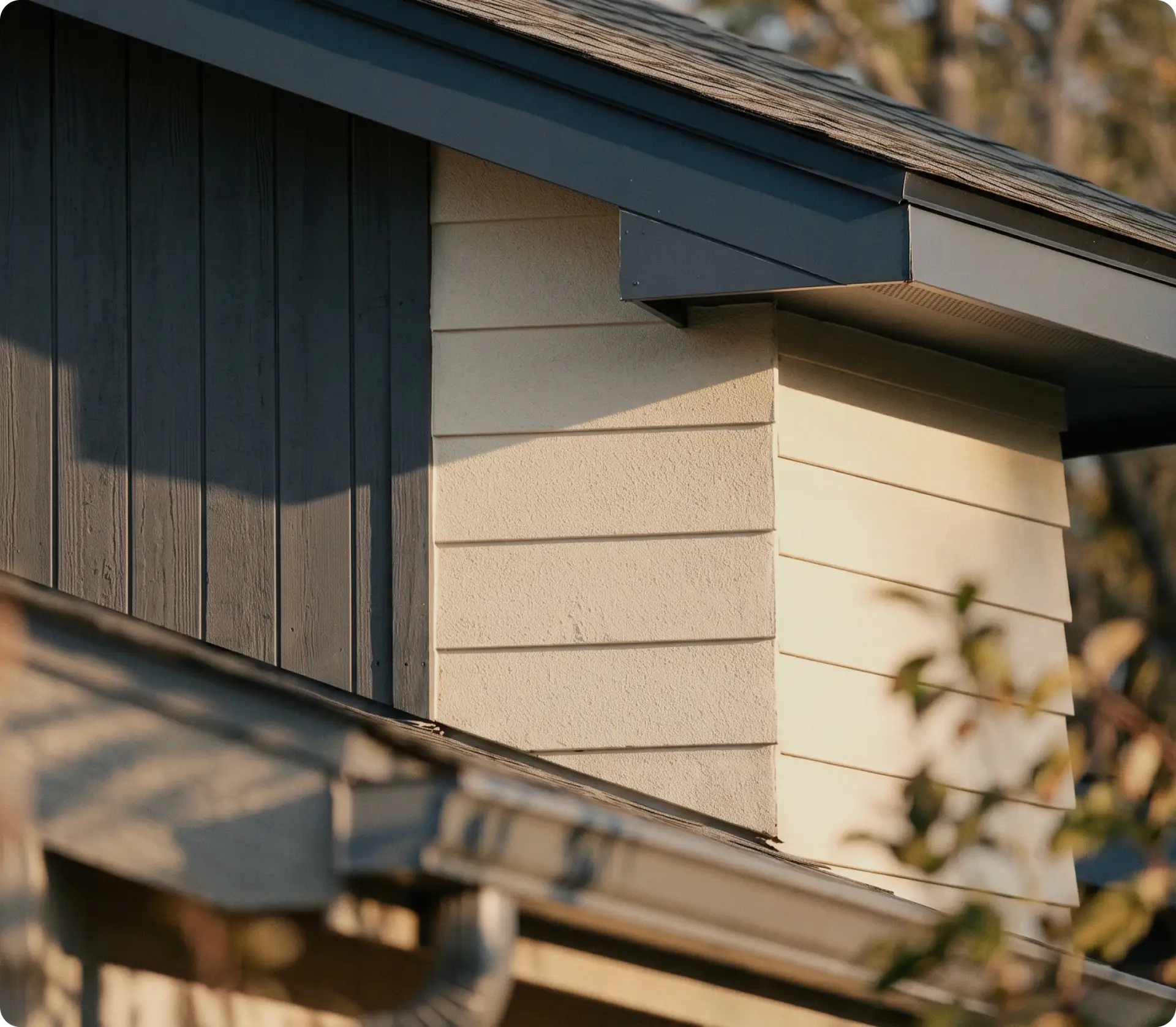 Close-up of a finished home exterior with board-and-batten and lap siding under the eaves at sunset