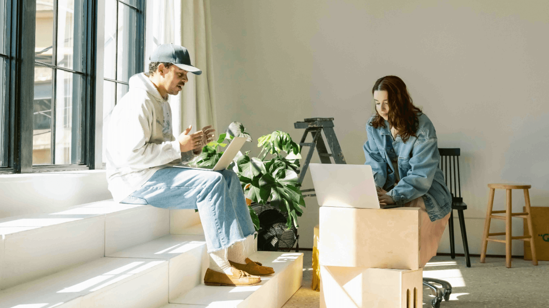 Two strategists working on laptops in a modern studio space