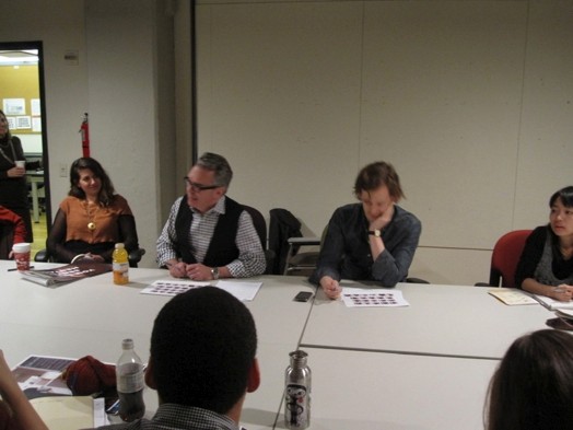 A photo of a group of people sitting at a conference table.