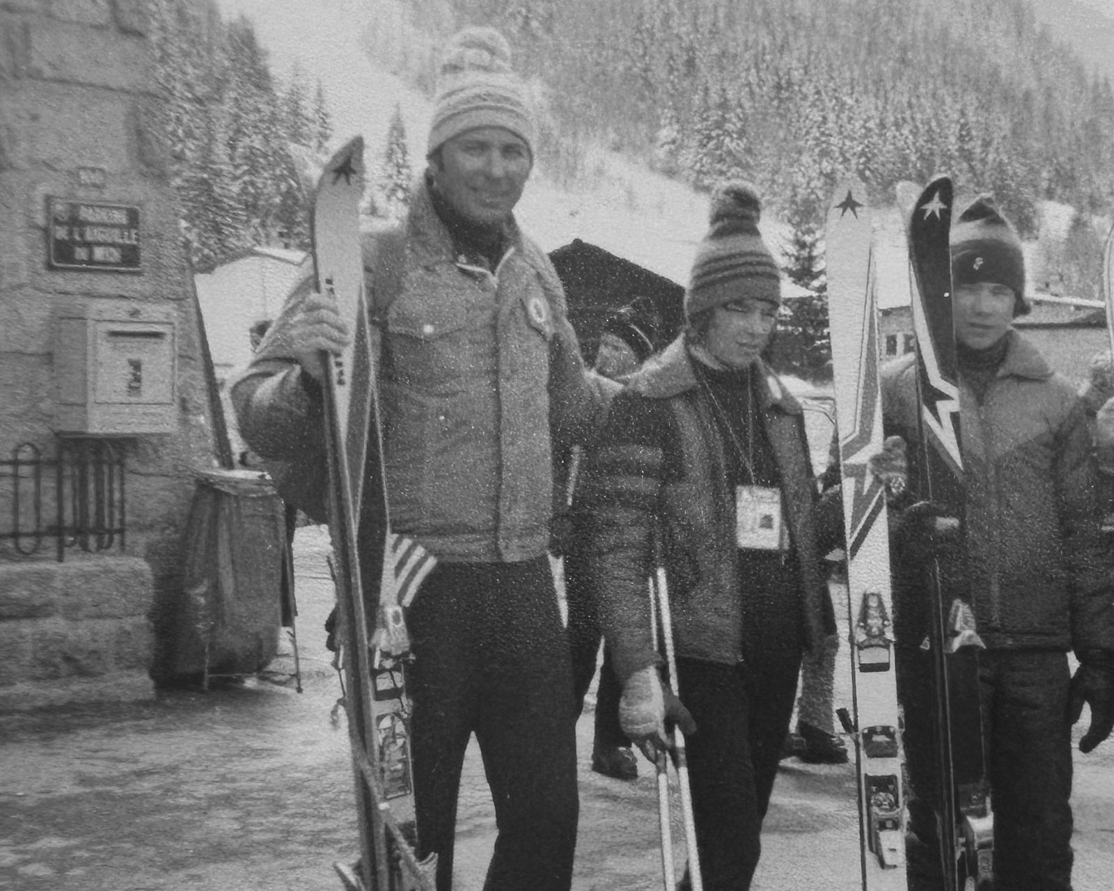 Vintage black-and-white photo of Norm McIntyre, Tim McIntyre, and Don McIntyre standing outdoors in ski attire, holding skis, with snowy trees and a ski lodge in the background, capturing a winter scene from the mid-20th century.