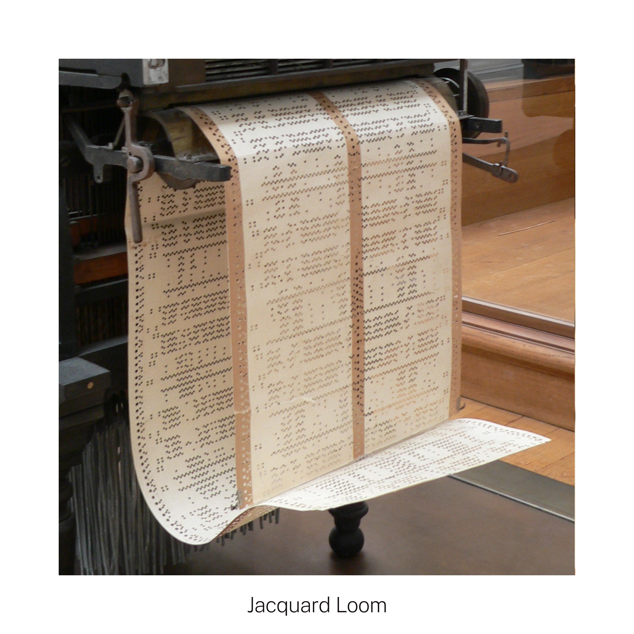 A Jacquard loom with woven punch cards hanging, showcasing intricate patterns for fabric production.