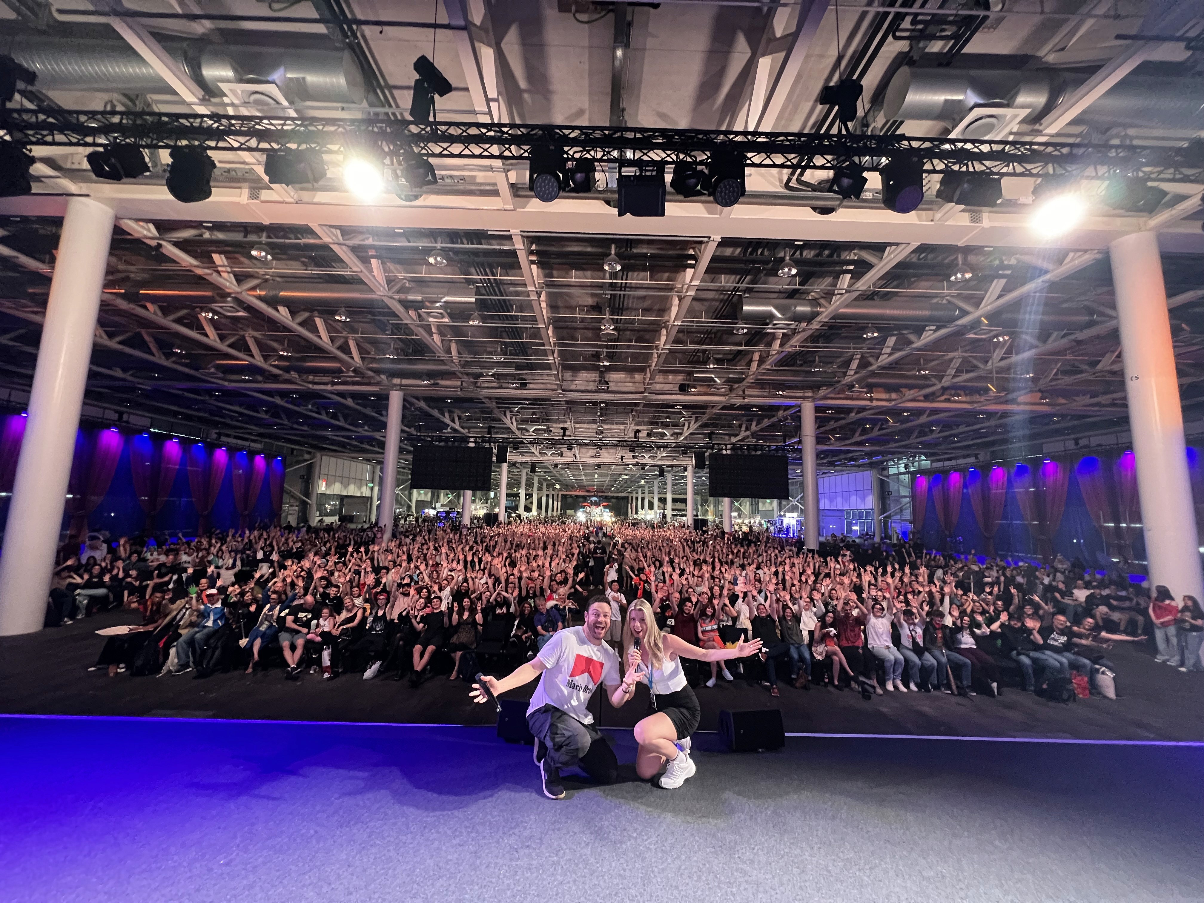 Moderatorin Désirée Lehmann zusammen mit Hollywood-Schauspieler Ross Marquand auf der Bühne einer ComicCon mit einem grossen Publikum hinter ihnen.