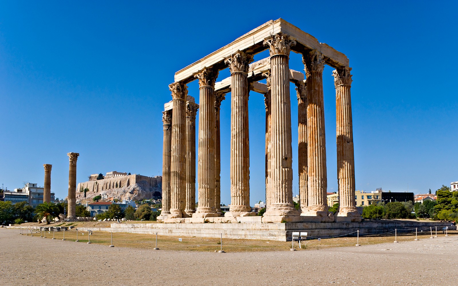 背景是雅典卫城的奥林匹亚宙斯神庙，雅典。