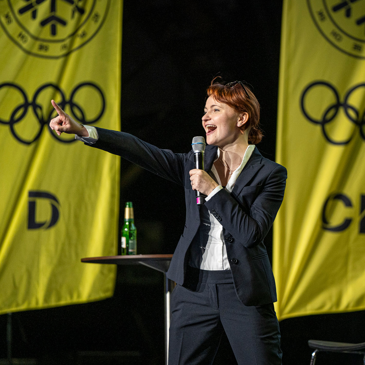 Keynote speaker addressing the audience on stage during a corporate conference presentation.