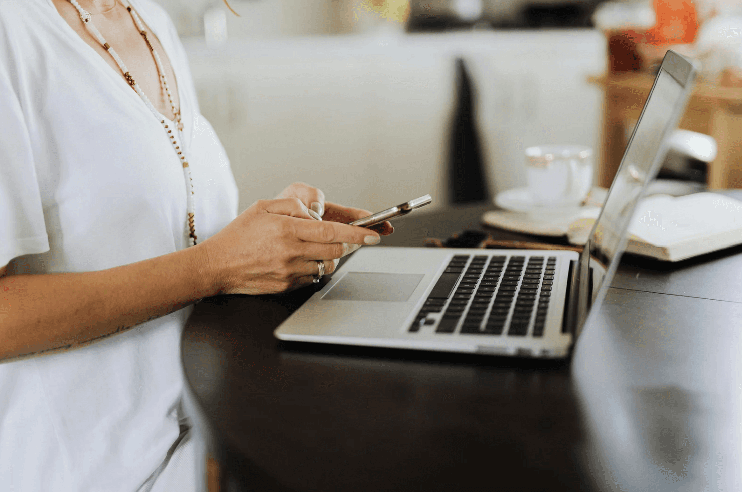 Amazon seller analyzing PPC campaign performance on laptop and smartphone to identify overlapping ads