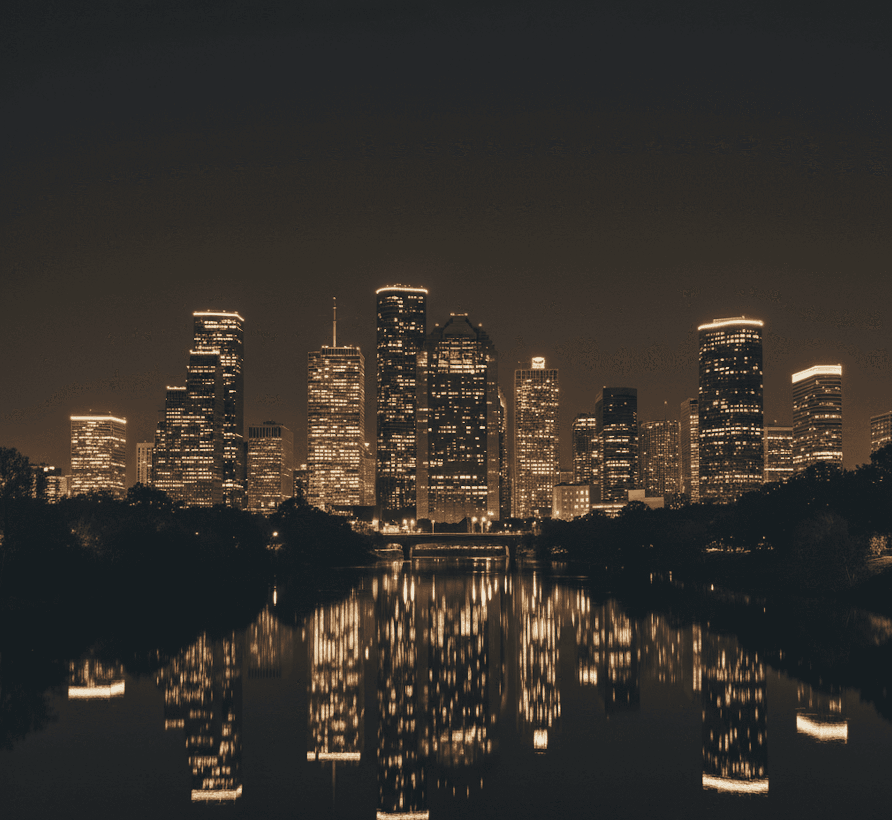 Houston, TX skyline at night reflected on Buffalo Bayou — luxury city backdrop for Prestige Wine Cellars service areas.