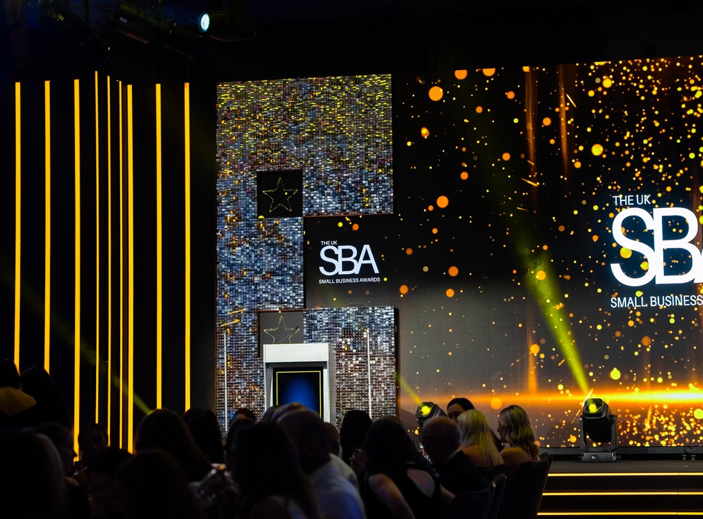 UK Small Business Awards 2025 stage featuring a large LED video wall, illuminated steps, custom scenic panels and event lighting in Birmingham.
