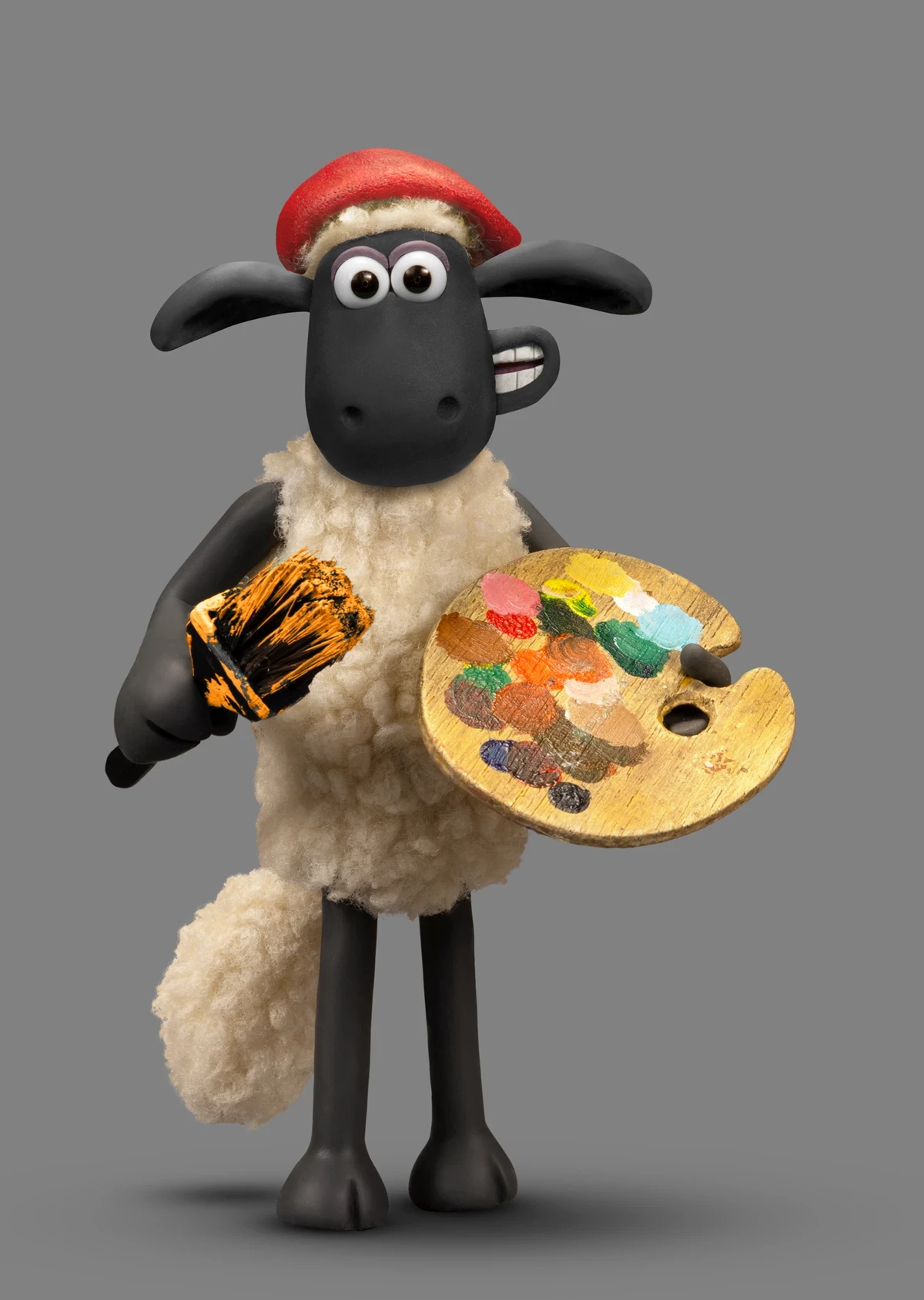 A cartoon-style sheep wearing a red beret holds a paintbrush in one hoof and a colourful artist’s palette in the other, standing against a plain grey background.