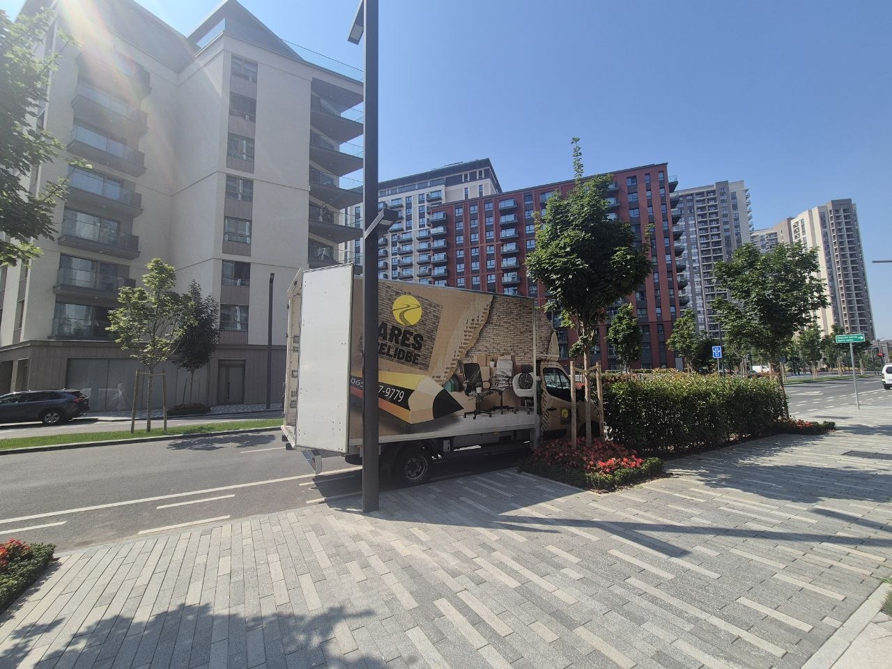 Kamion za selidbu parkiran ispred modernih stambenih zgrada u urbanom naselju