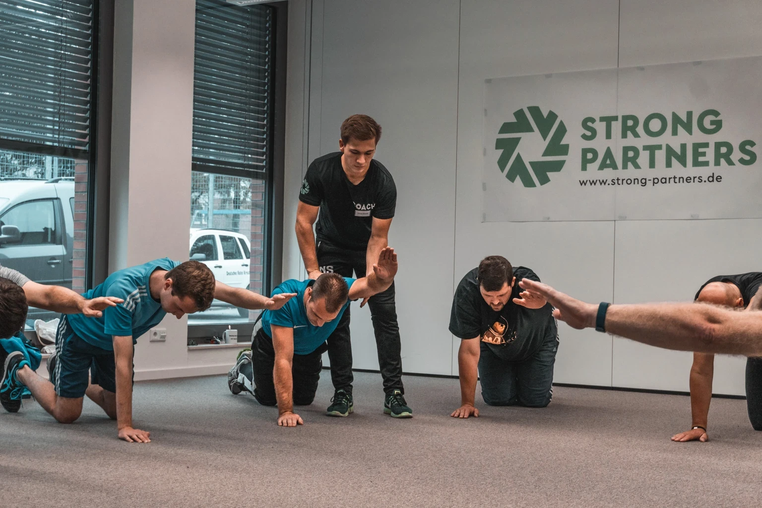 Strong Partners Coach korrigiert Sportübungen