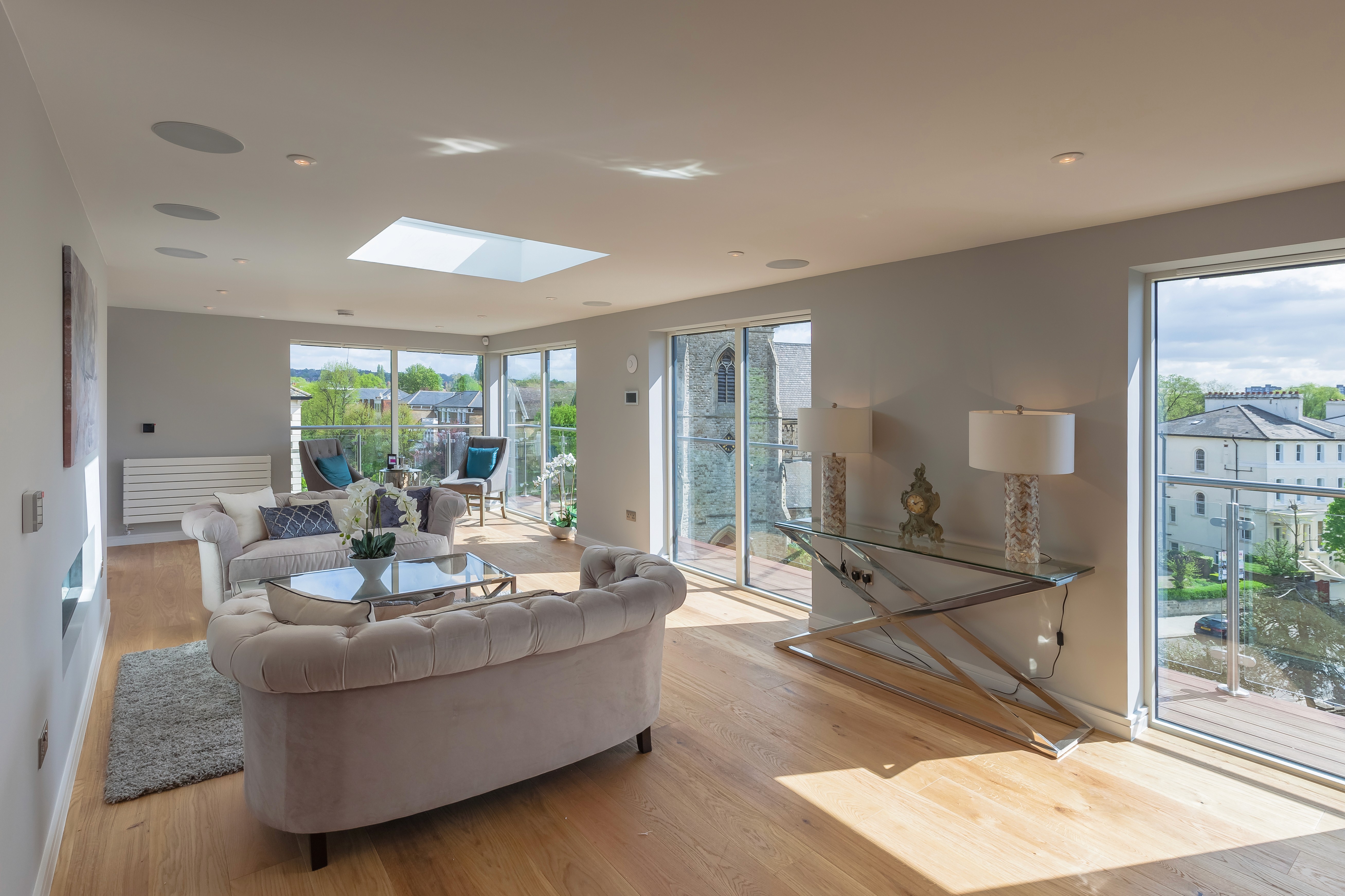 Modern minimalist house with large glass windows and a flat roof, surrounded by lush greenery. A serene pool reflects the trees and the sky. Peaceful ambiance.
