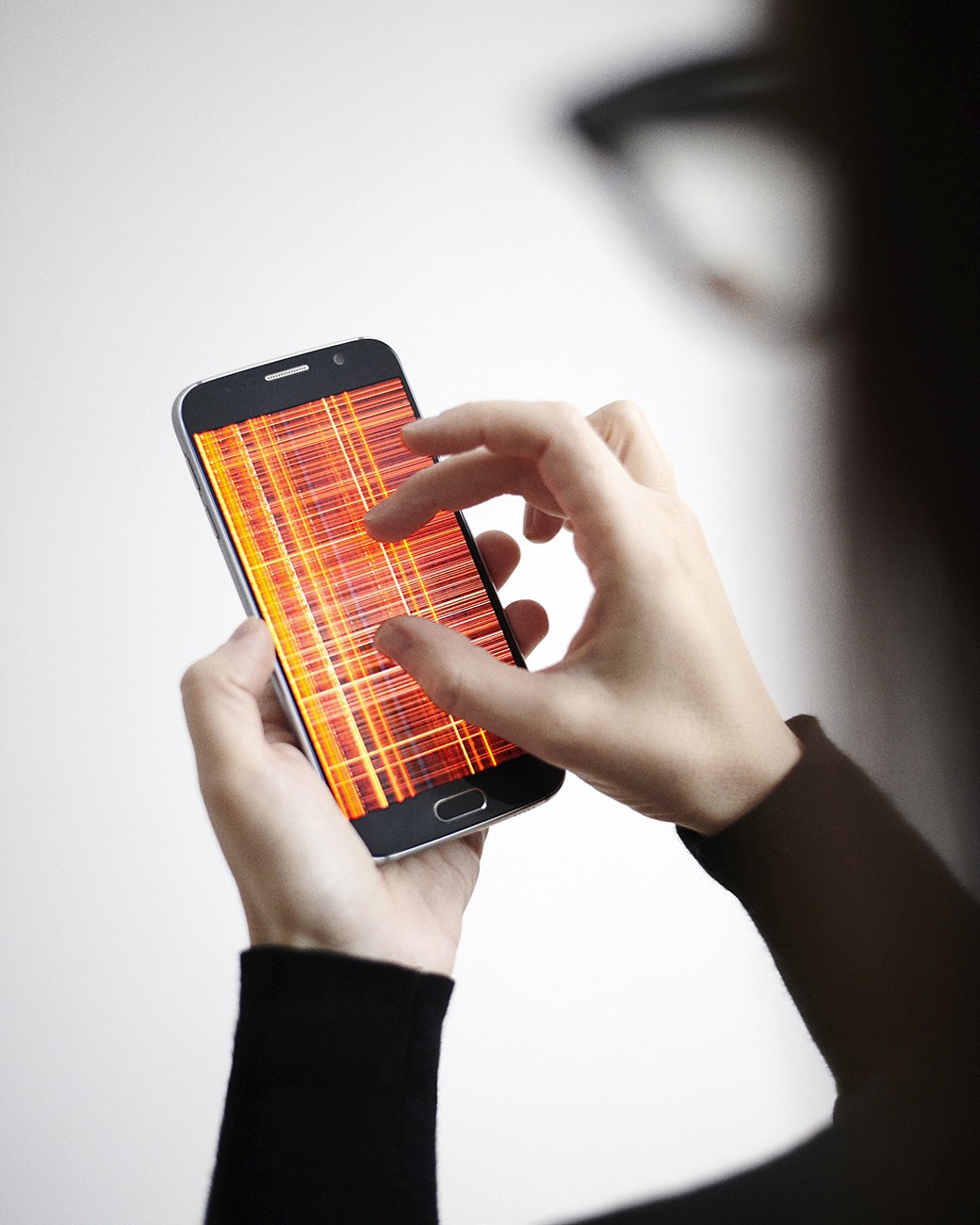 Woman's hand enlarging a mobile phone screen with the work Hotnoise by MIL111