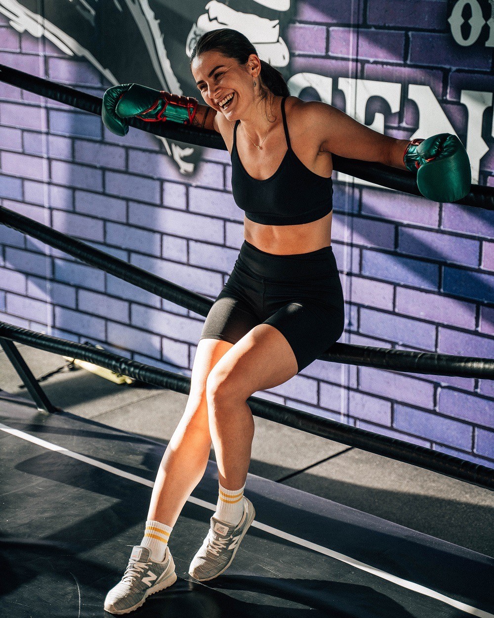 Rachel, personal trainer, looking to the side confidently in a fitness studio