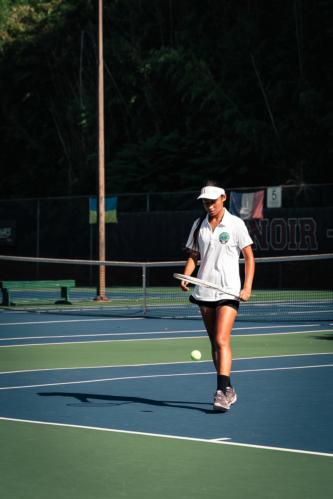 Joueuse concentrée sur le court extérieur du Combine Elite Tennis Camp.