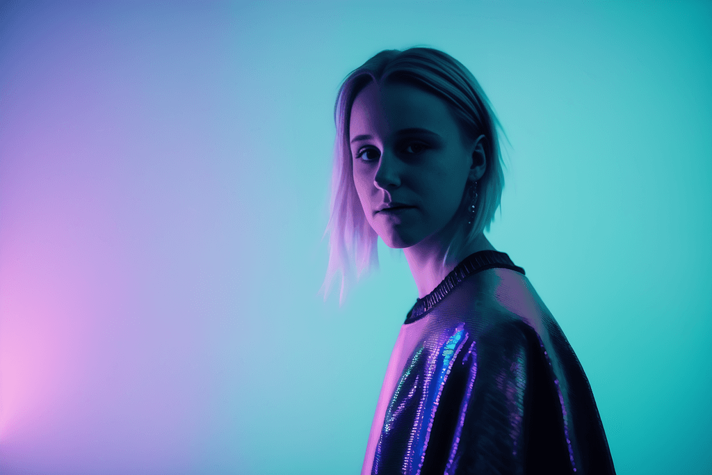 Annika with short hair in front of blue purple neon lights