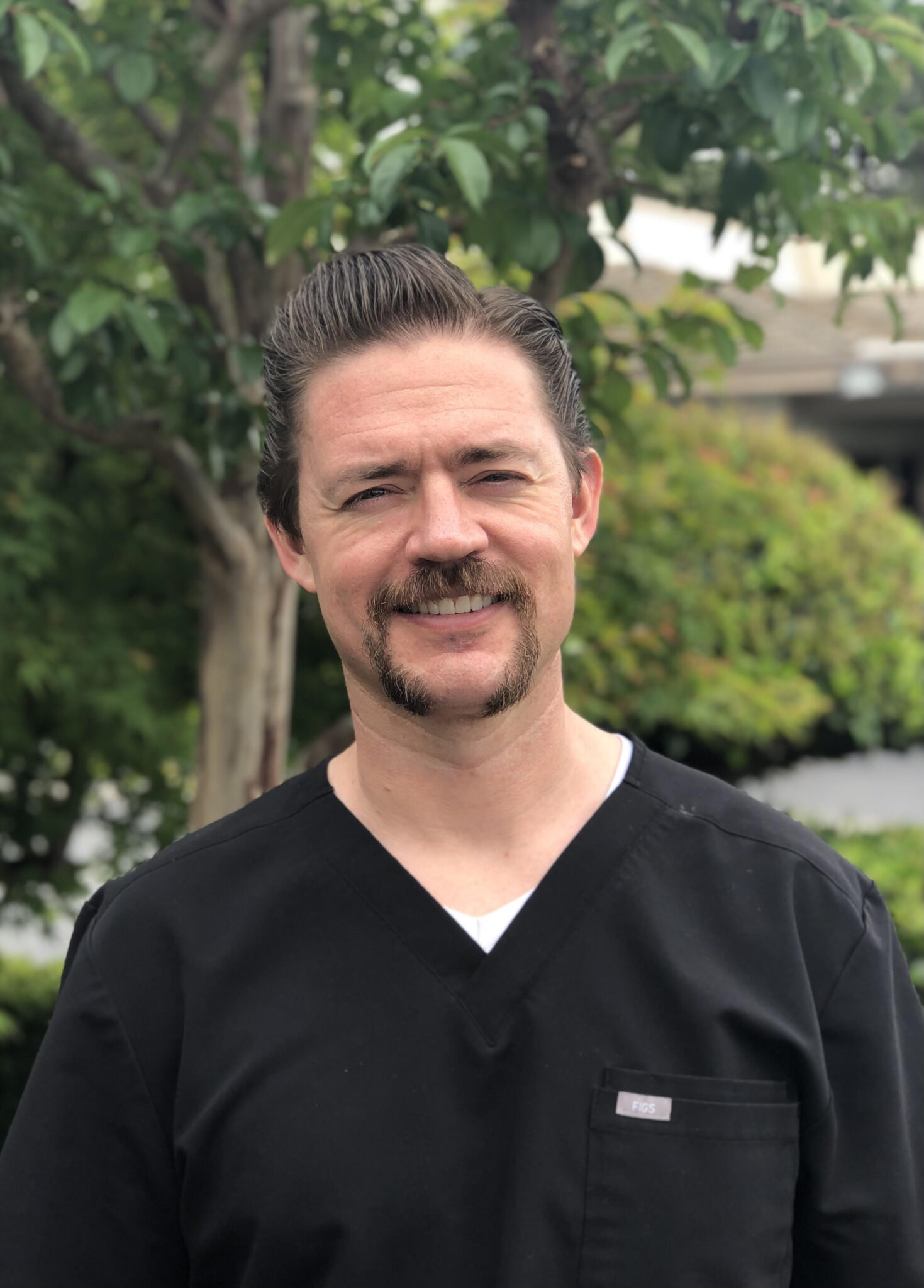 person writing on brown wooden table near white ceramic mug