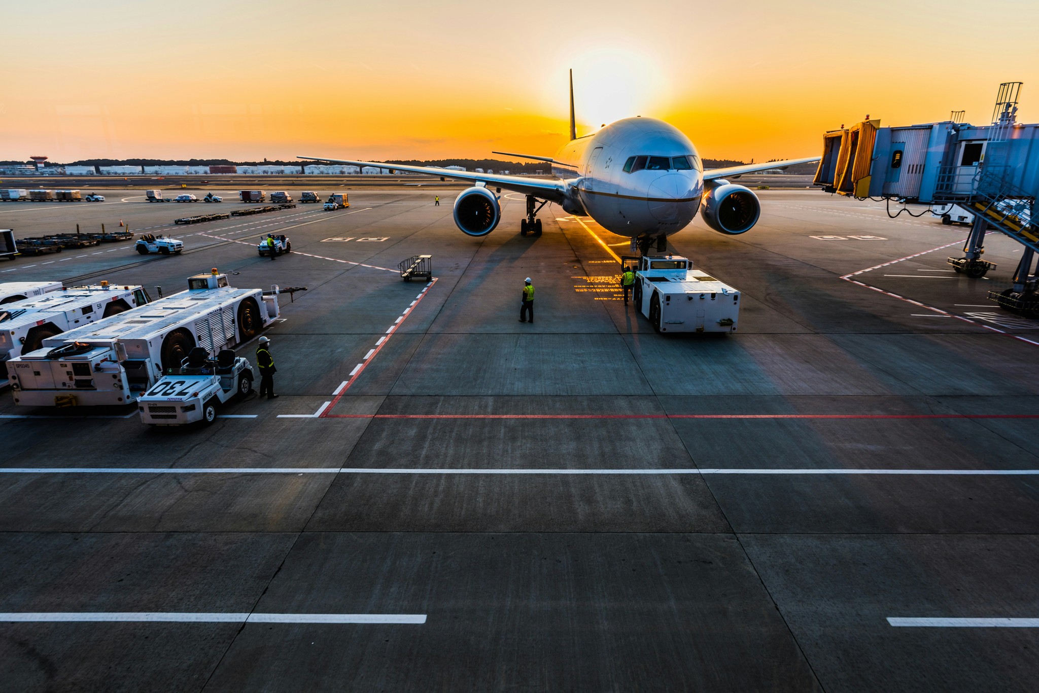 An airplane parked at an airport gate during sunset, symbolizing Kowee’s expertise in optimizing parking and pricing strategies for transportation hubs.