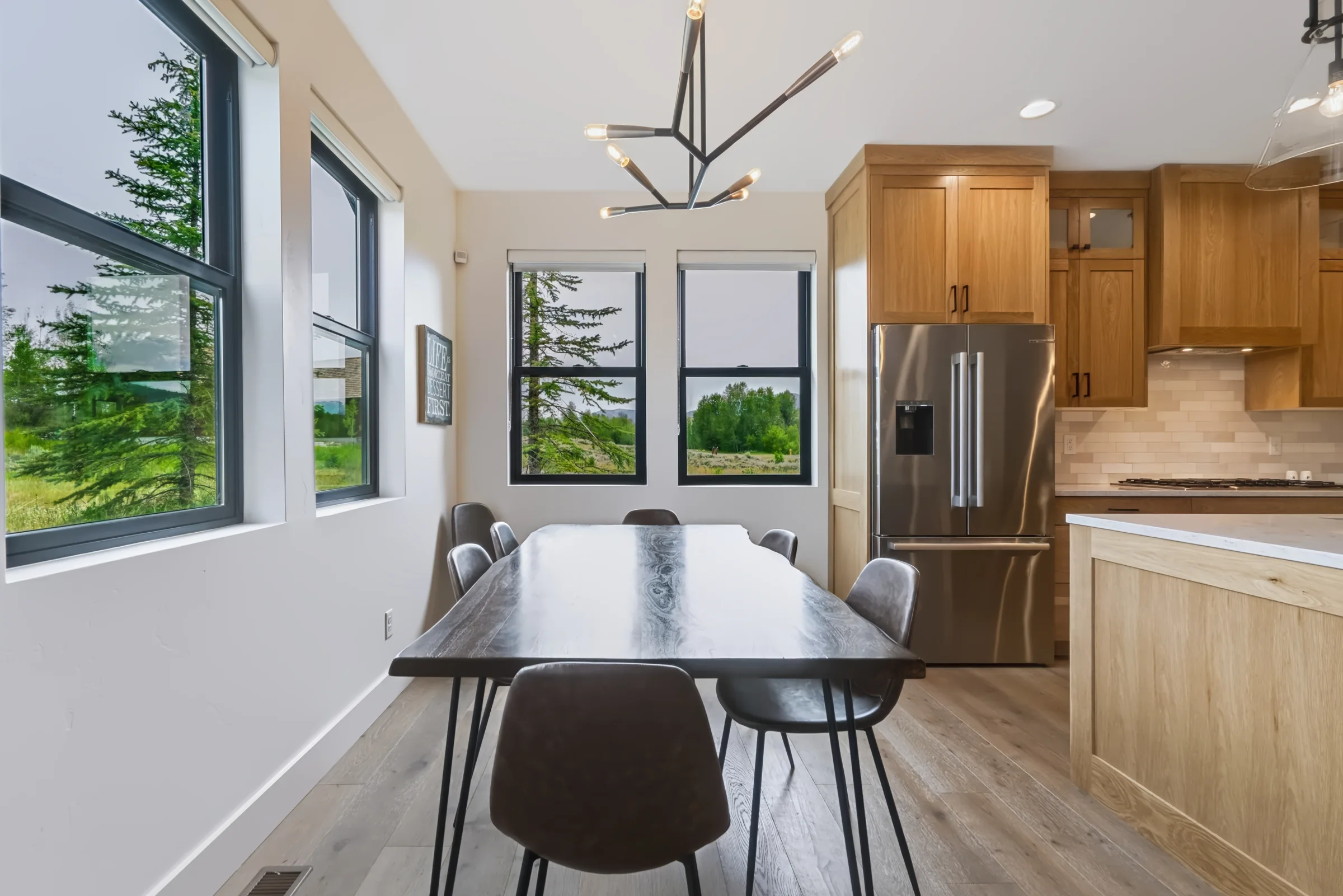 Dining area beside the kitchen with forest views