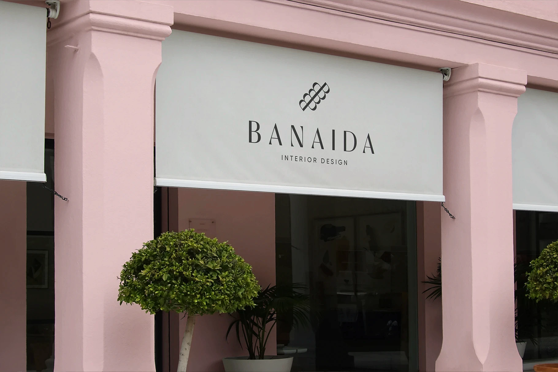 Luxury storefront awning mockup on a pink building facade with a minimalist logo.