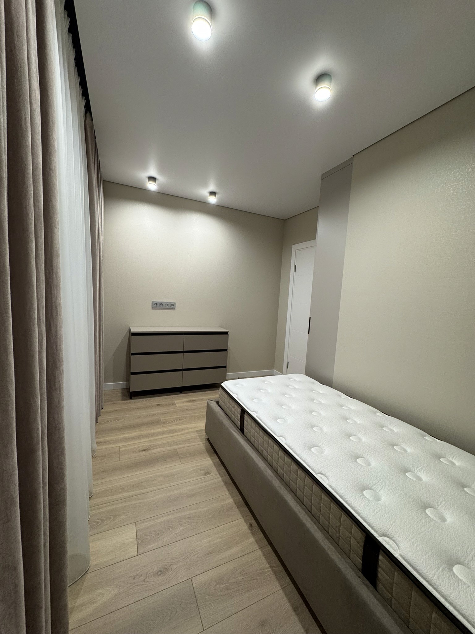 Невелика спальня з односпальним ліжком і комодом біля стіни