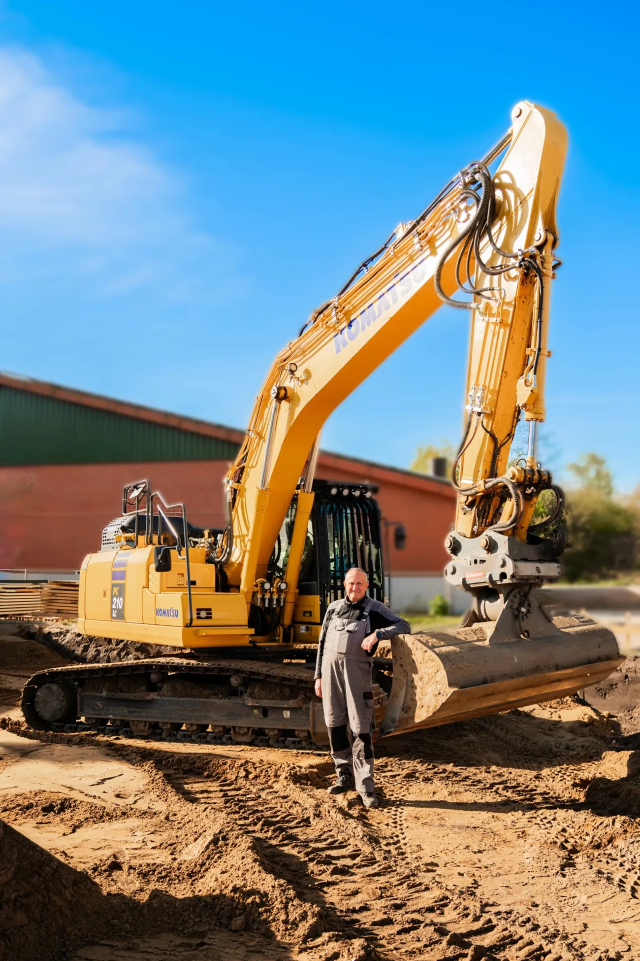Gelber Komatsu-Radlader mit Mitarbeiter davor auf dem Betriebsgelände