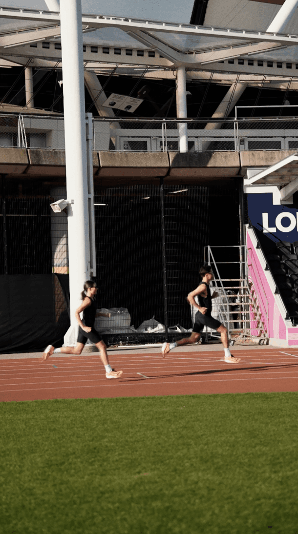 Bride in white dress walking on street, man in background