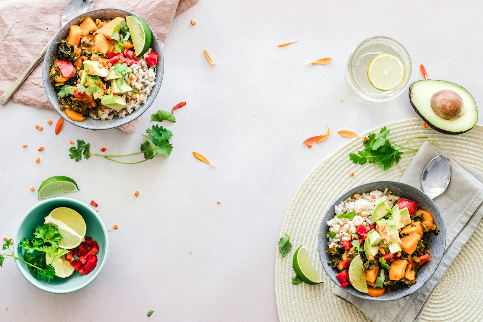 Overhead view of balanced grain-and-vegetable bowls with avocado and lime, a sustainable everyday way of eating for Hashimoto's