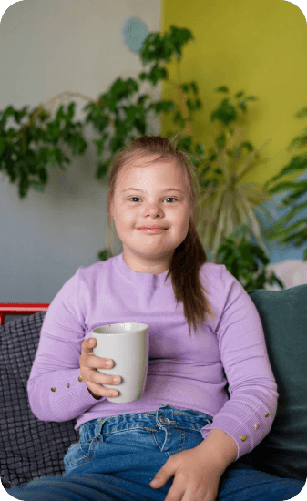 criança com sindrome de down segurando um copo