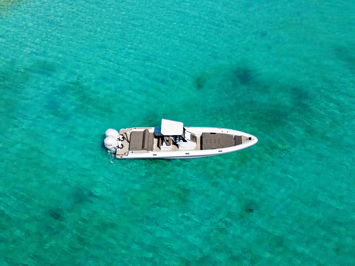 White and green RIB speedboat Rock 36 Naboo cruising calm blue waters with mountainous Greek coastline in background.