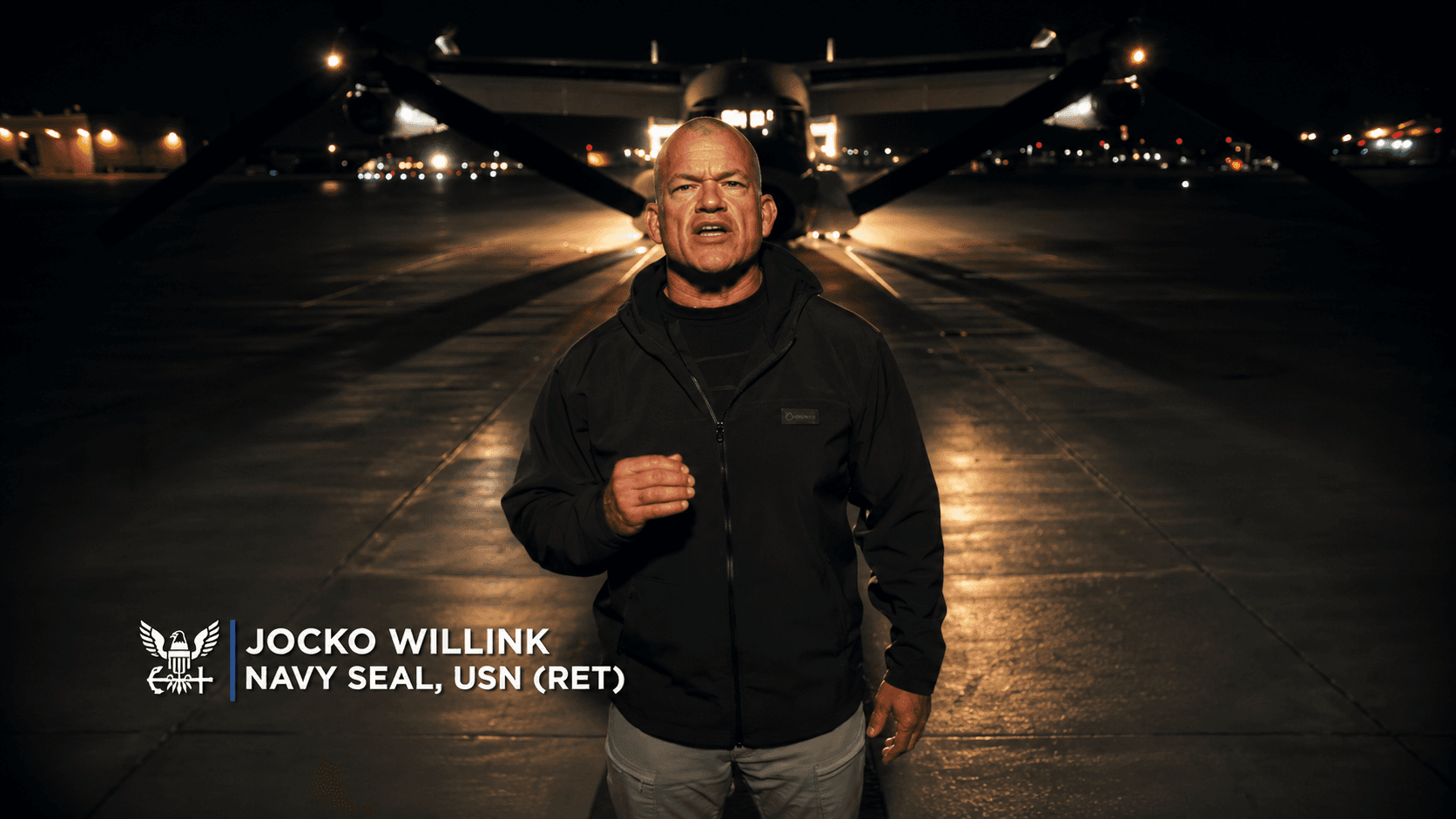 Jocko Willink Navy Seal in front of plane speaking to camera