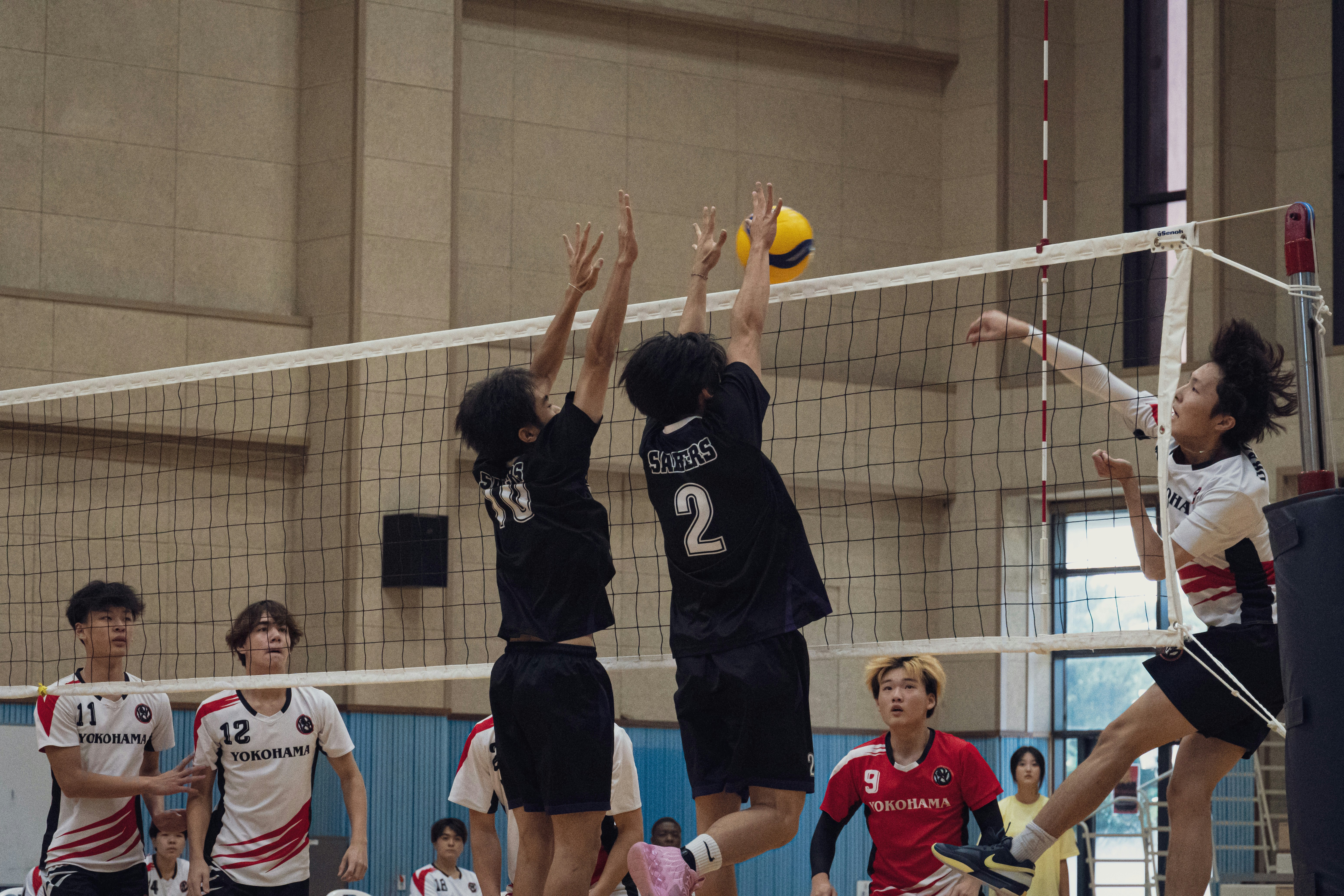 A group of young people playing a game of volleyball