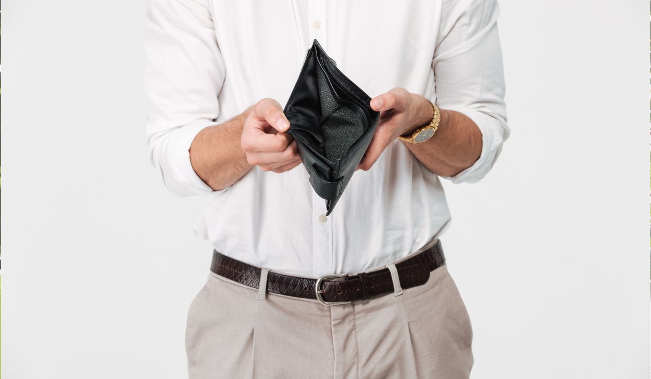 Imagem mostra homem segurando carteira vazia e sem dinheiro no fim do mês