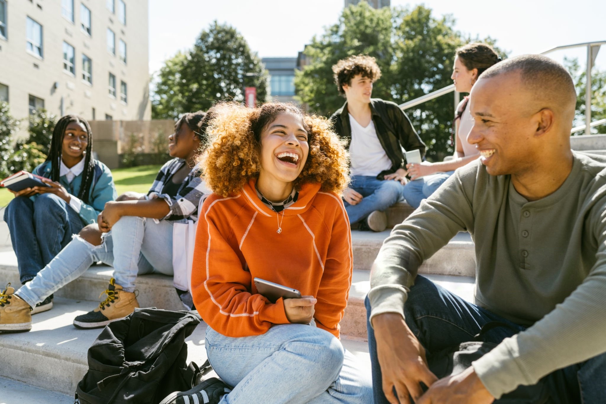 International students sitting together outdoors on a UK university campus.