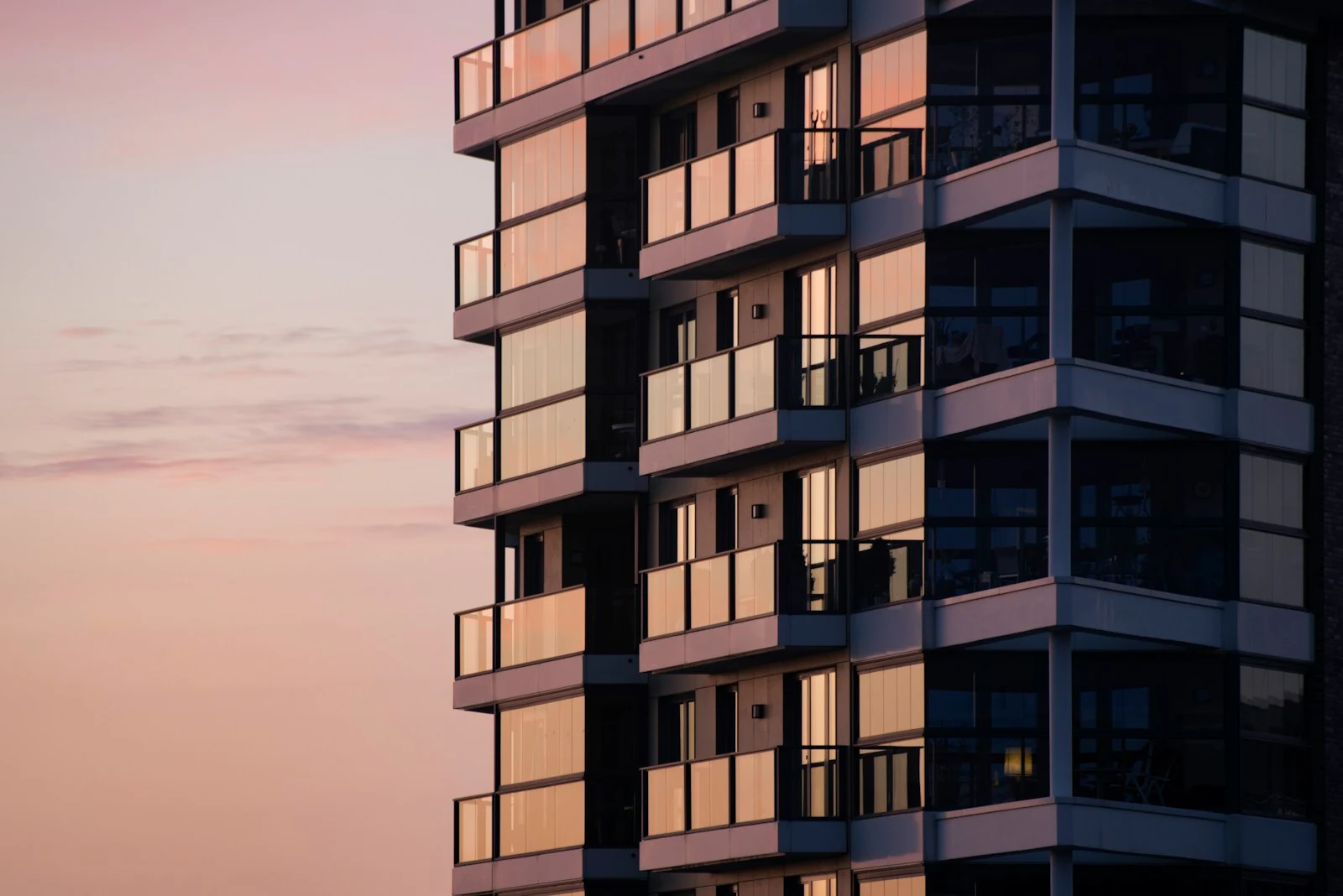 Modern apartment building at dusk, photo by Tobias Wilden on Unsplash