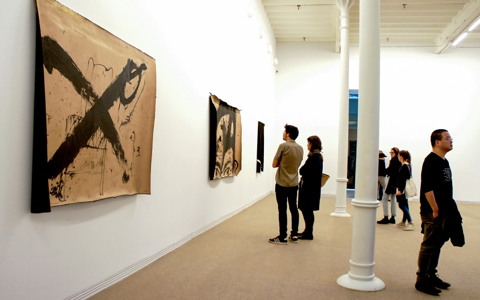 Besökare som tittar på abstrakt konst på Fundació Antoni Tàpies, Barcelona.