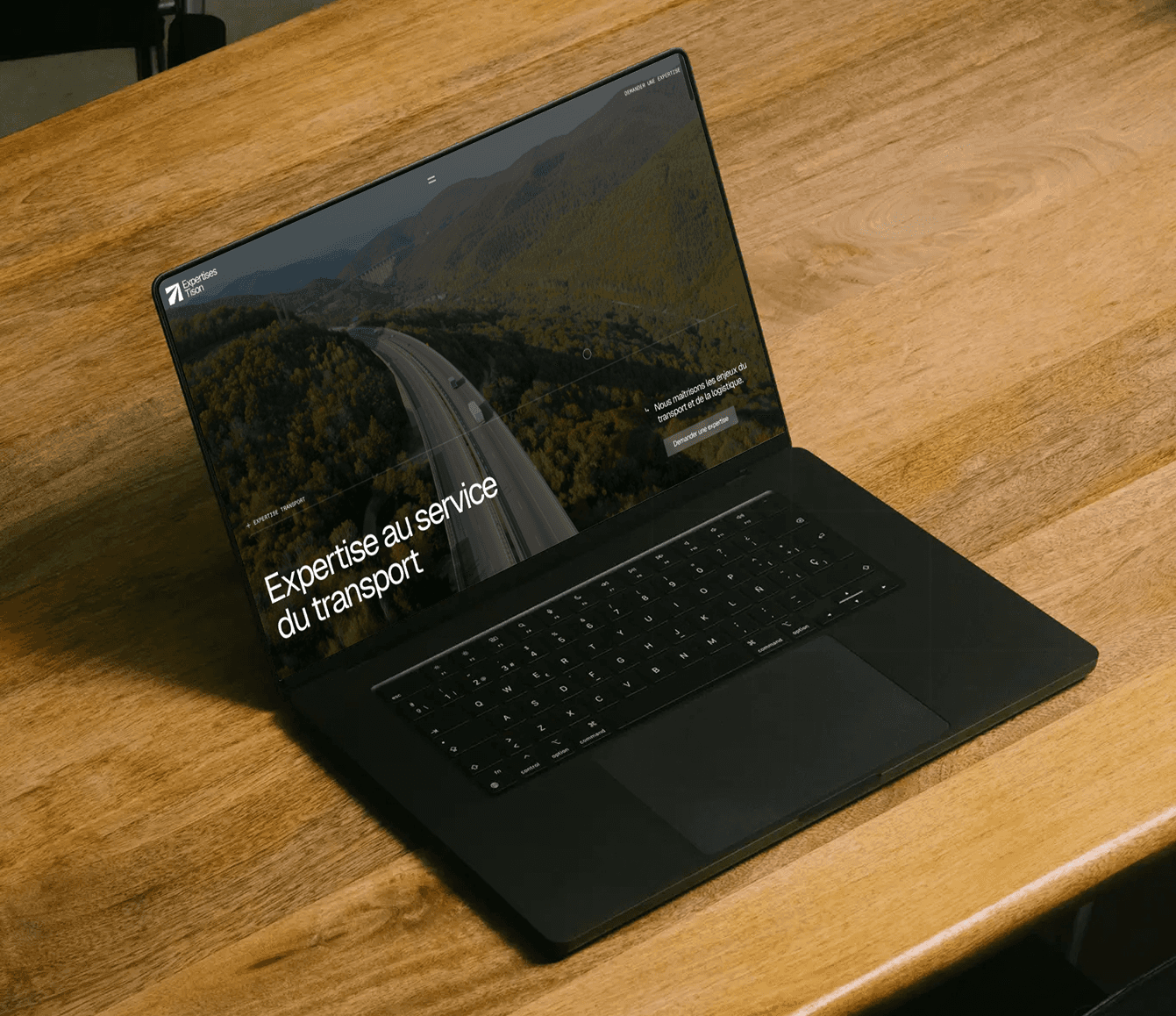 Ordinateur sur une table en bois avec le site Expertises Tison