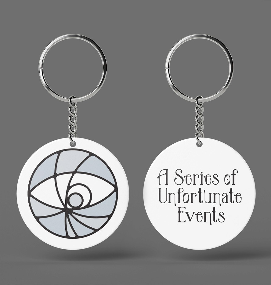 A mockup of the movie merchandise keychain. A white round plastic keychain with black writing for the movie logo.