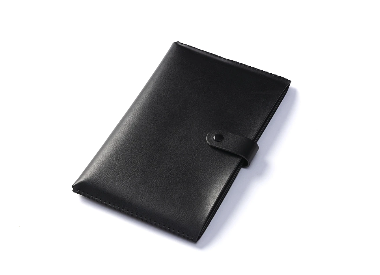 Closed black leatherette notebook with snap strap.