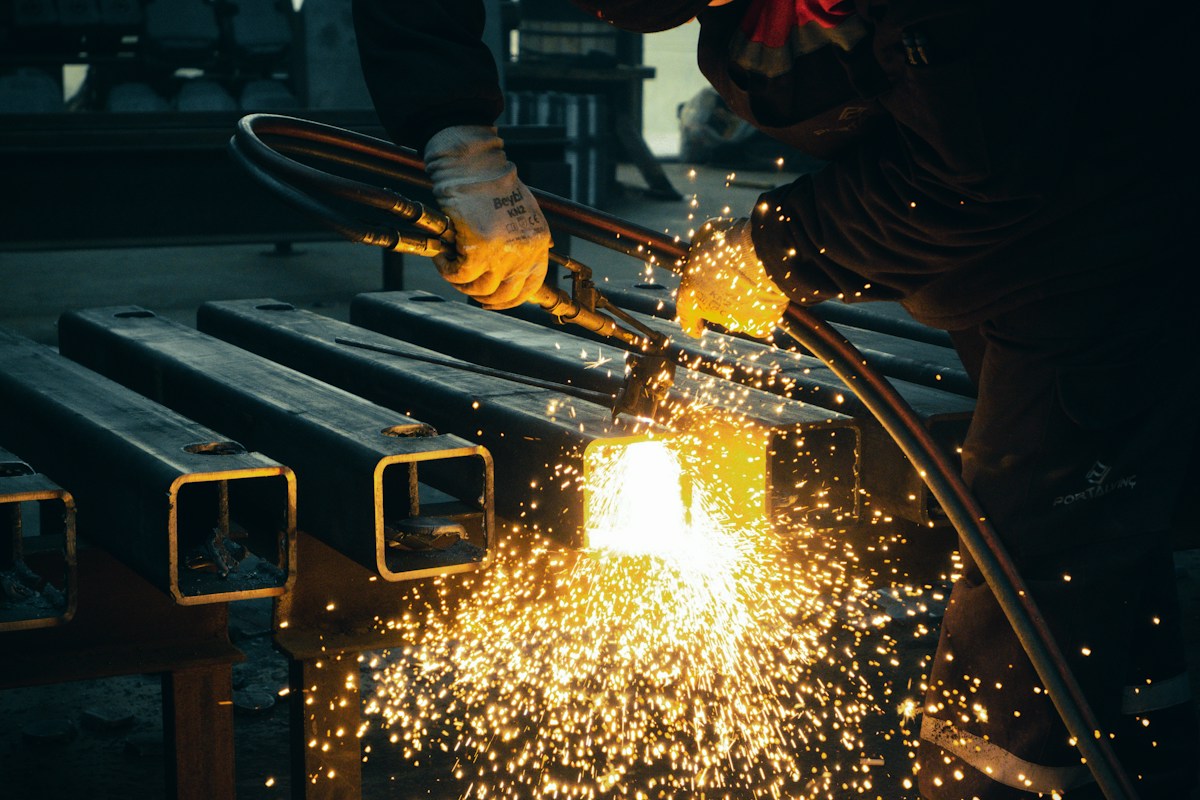 Welder fabricating industrial pipe racks