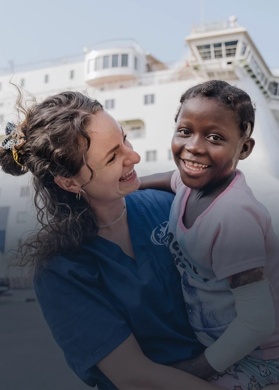 Female volunteer holding a young girl