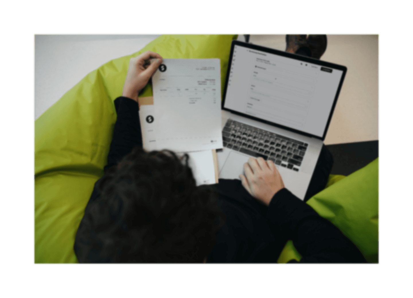 A person sitting on a bean bag chair working on a laptop
