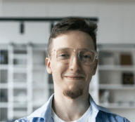 man in blue and orange button up shirt smiling