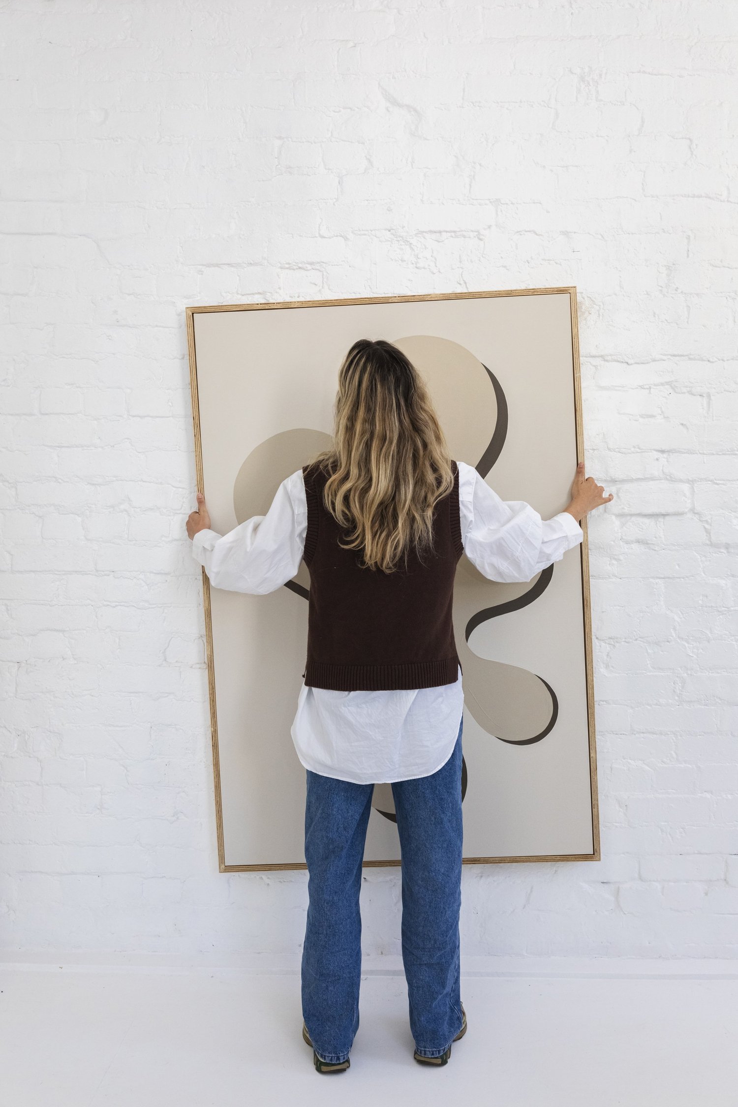 Artist hanging an abstract painting