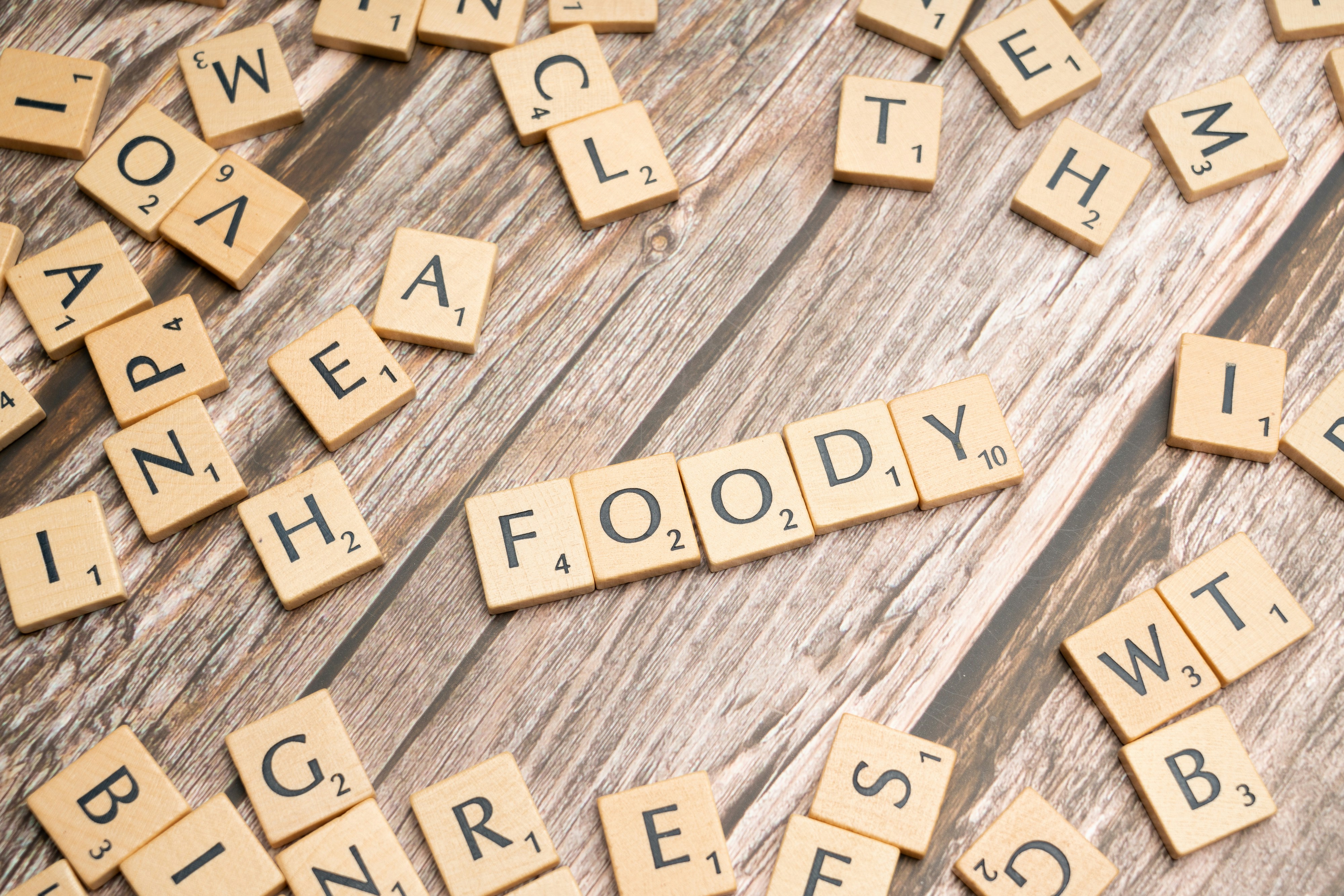 a close up of scrabble letters on a wooden surface