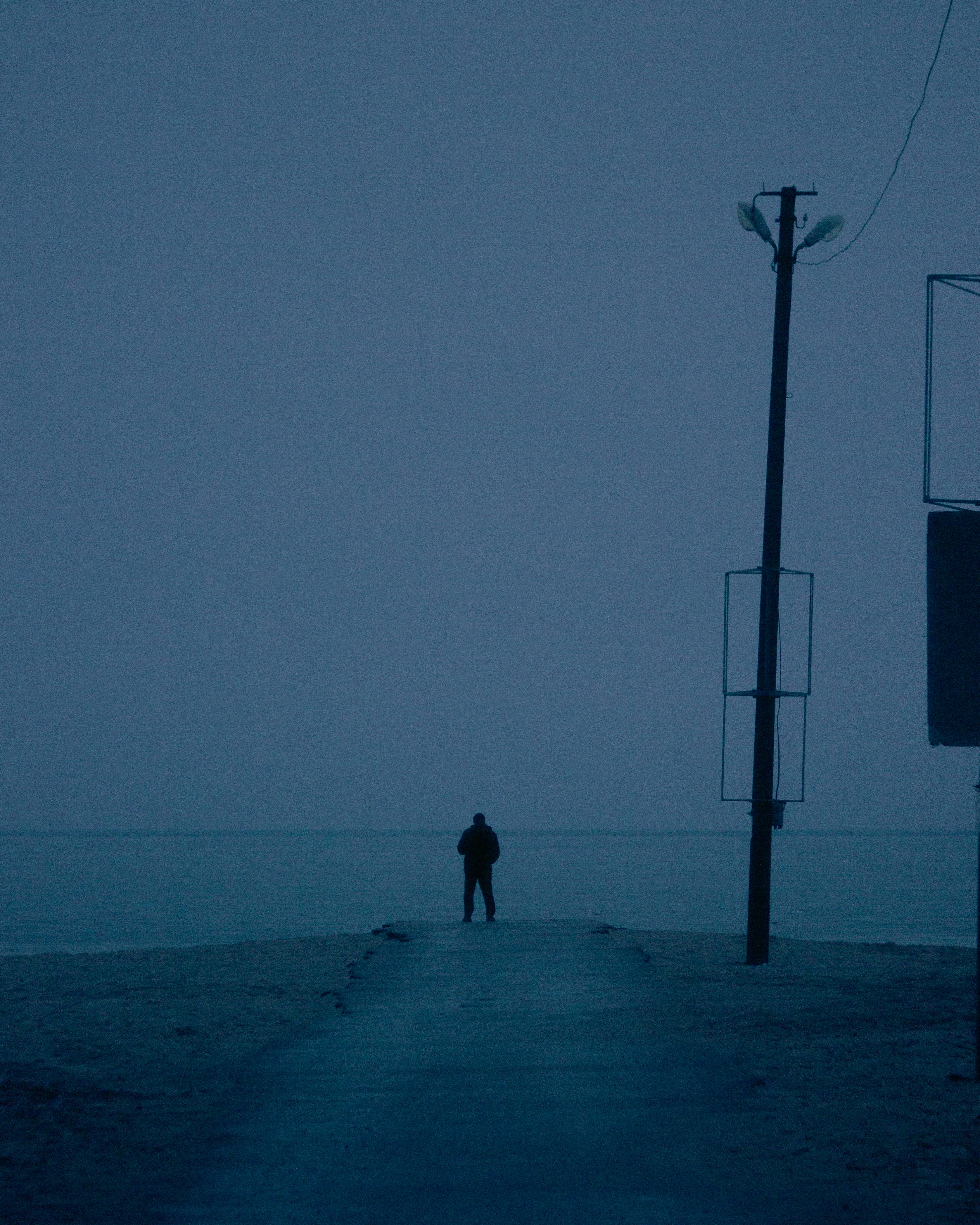 a person standing on a sidewalk in the dark