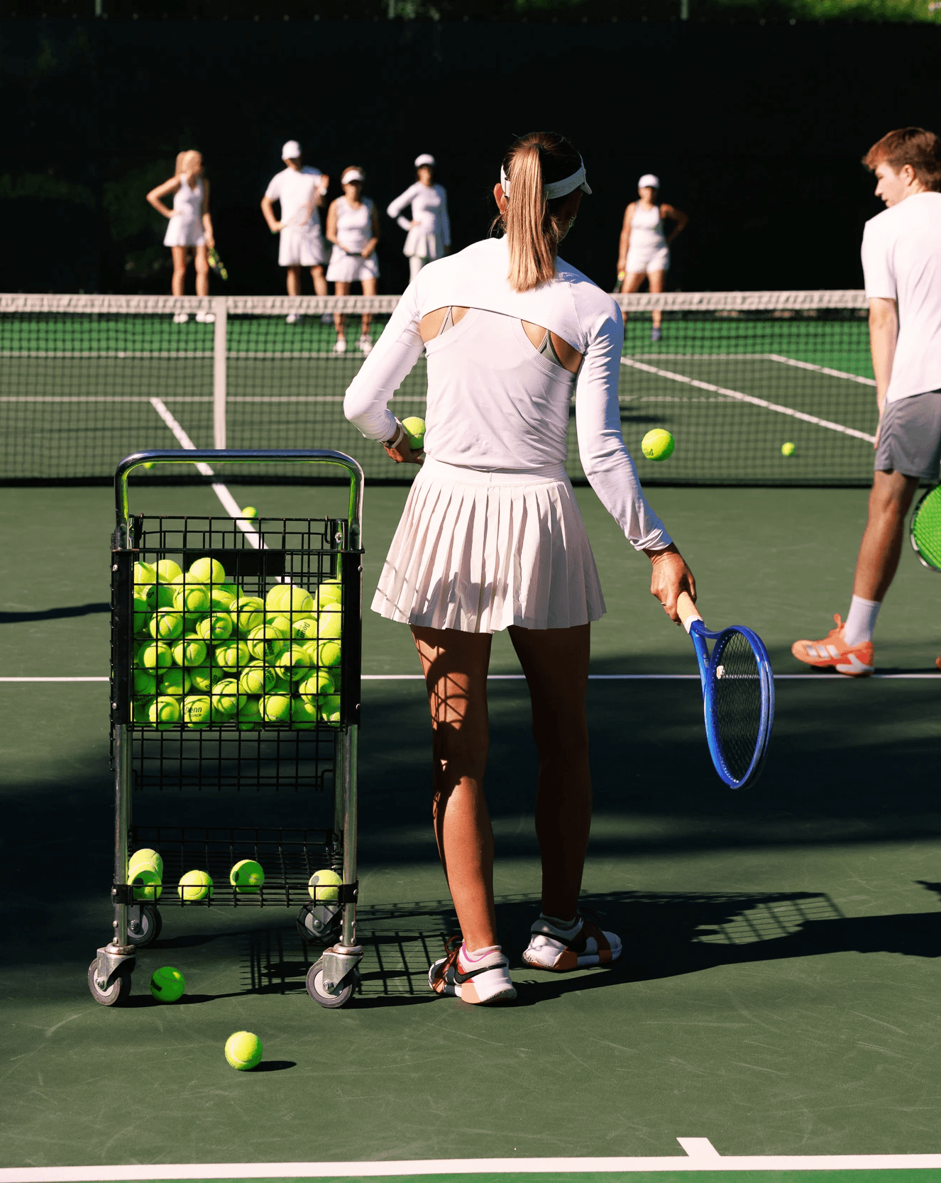 Tennis instructor and players